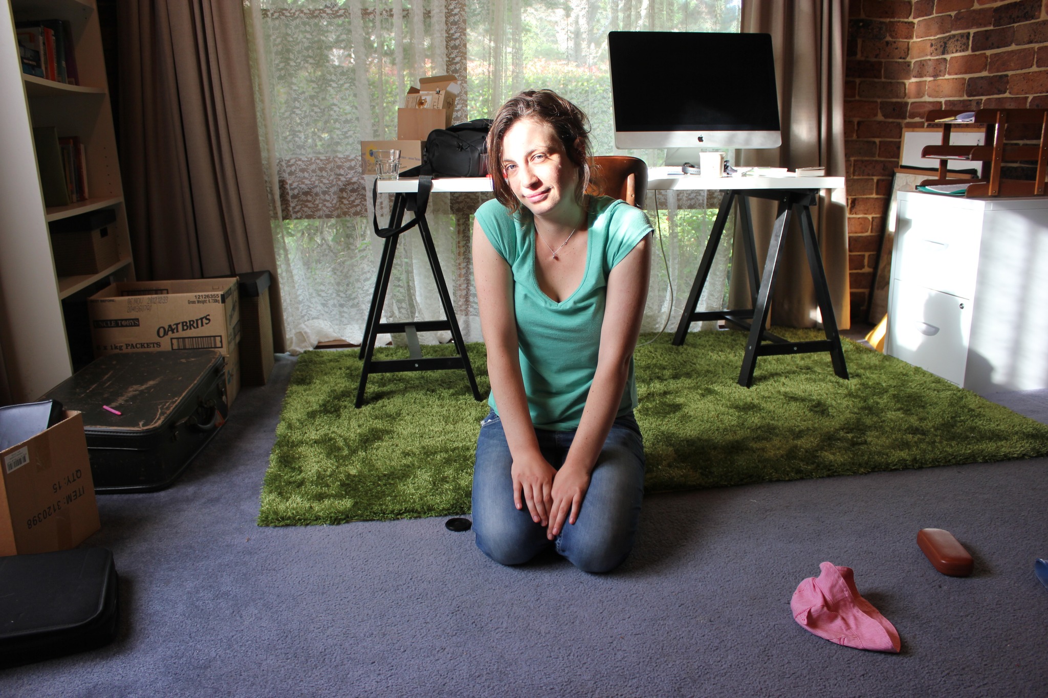 Young mum studying, sitting on the floor looking directly into the camera