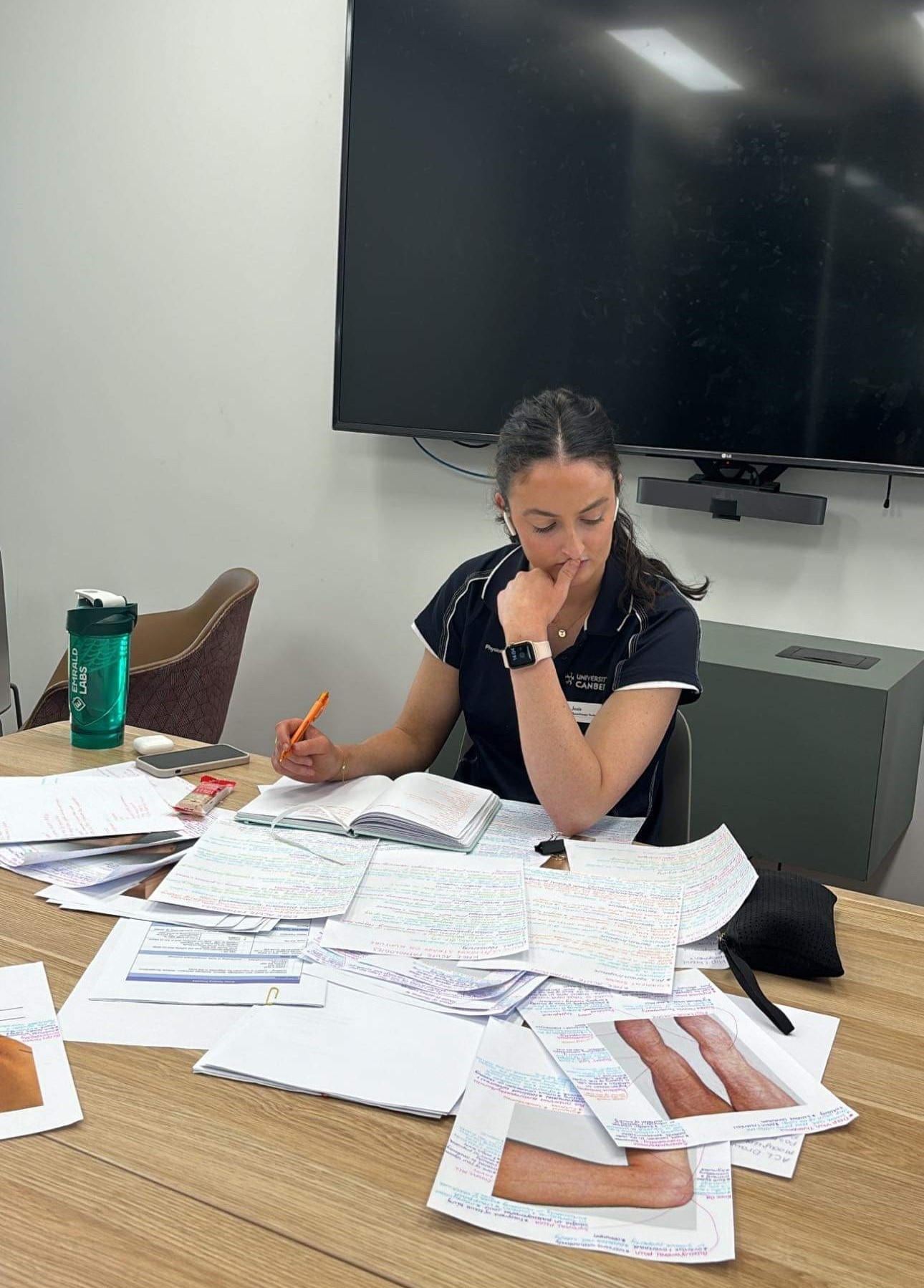 Josie deep in study with notes and papers spread across the table